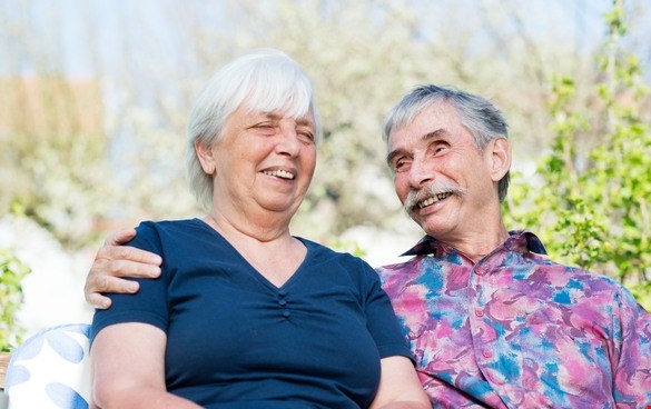 Ett äldre par skrattar och håller om varandra