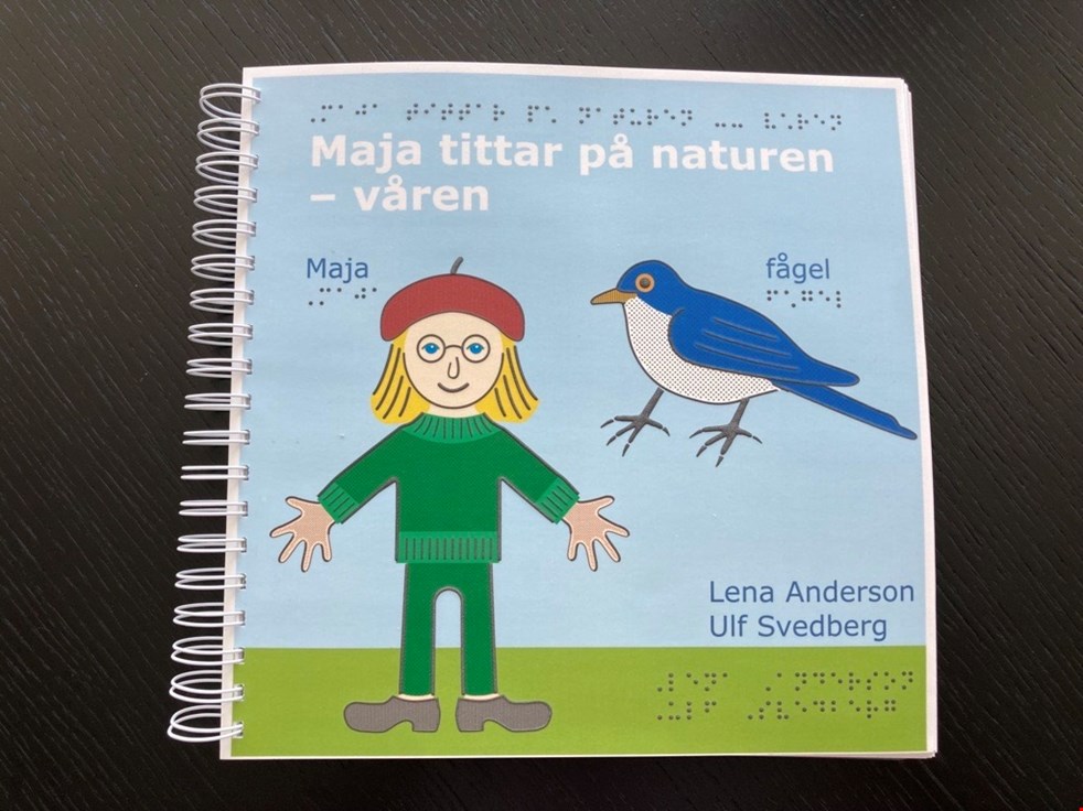 Omslaget till Maja tittar på våren med Maja som har gröna kläder och en blåvit fågel mot en ljusblå himmel.