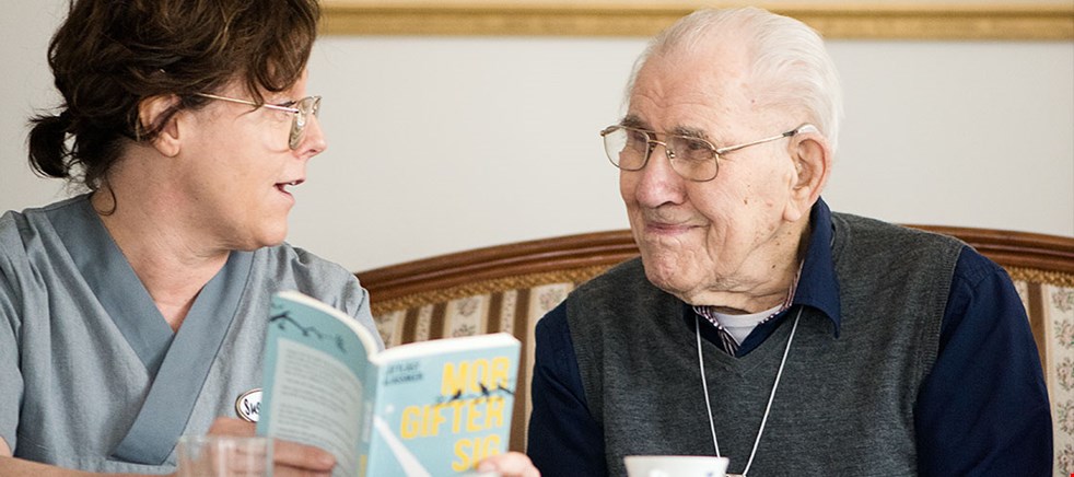 Ett läsombud läser för en äldre man.