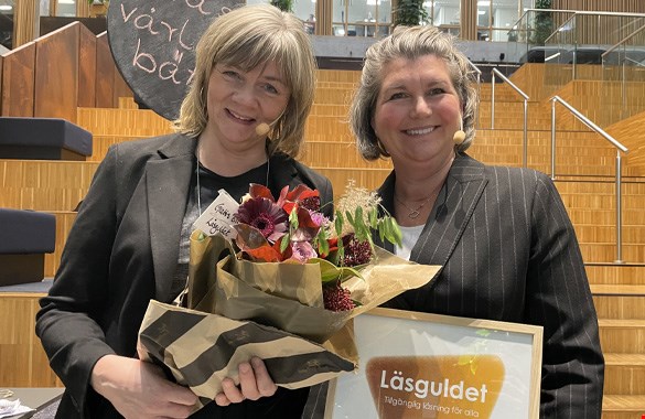 Britt-Inger Rörborn och Kristina Göransson håller i en blomma och ett diplom, och ler stort.