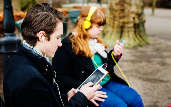 Teenagers reading with smartphone and tablet