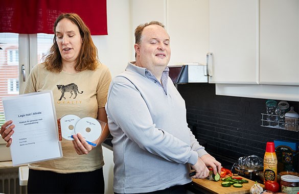 Bilden visar vinnarna av Läsguldet 2020. Eva Fridh och Martin von Knorring står i käket. Eva håller upp kokboken och Martin skär grönsaker. De båda ser glada ut.